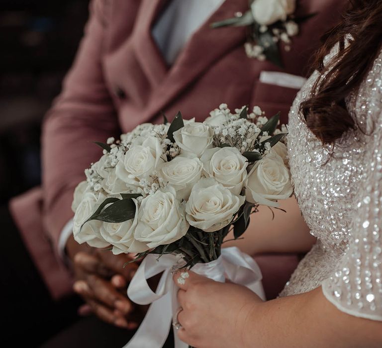 Bride holds white classic floral bouquet