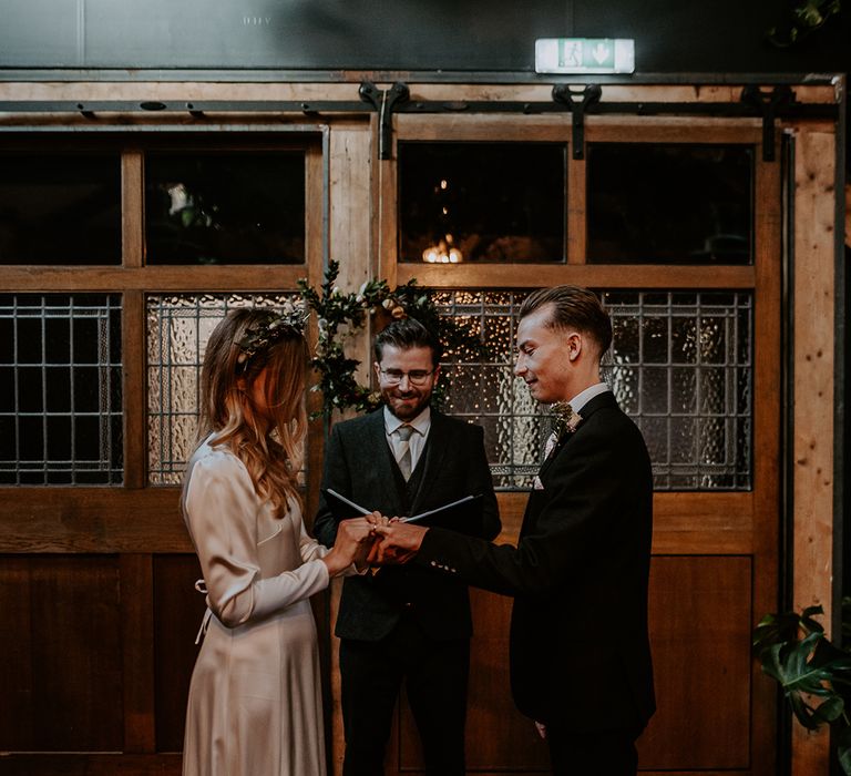 Bride & groom during wedding ceremony as they read vows to one another