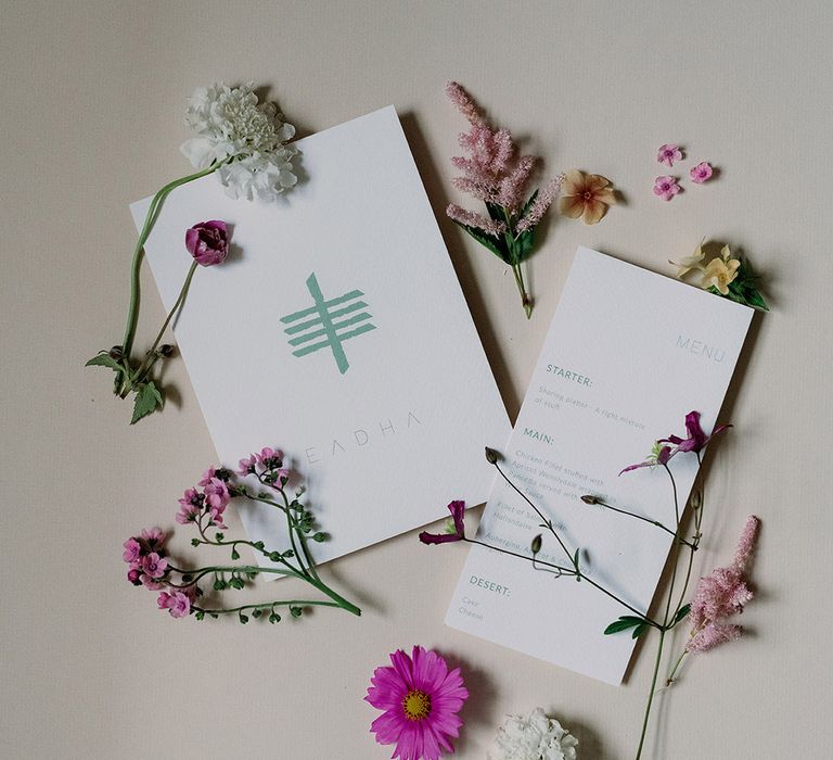 Green and white wedding stationery with colourful wildflowers