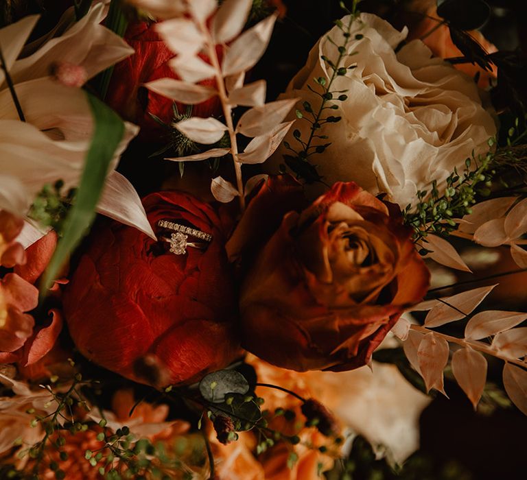 Bride's engagement ring and wedding band in flower of wedding bouquet 