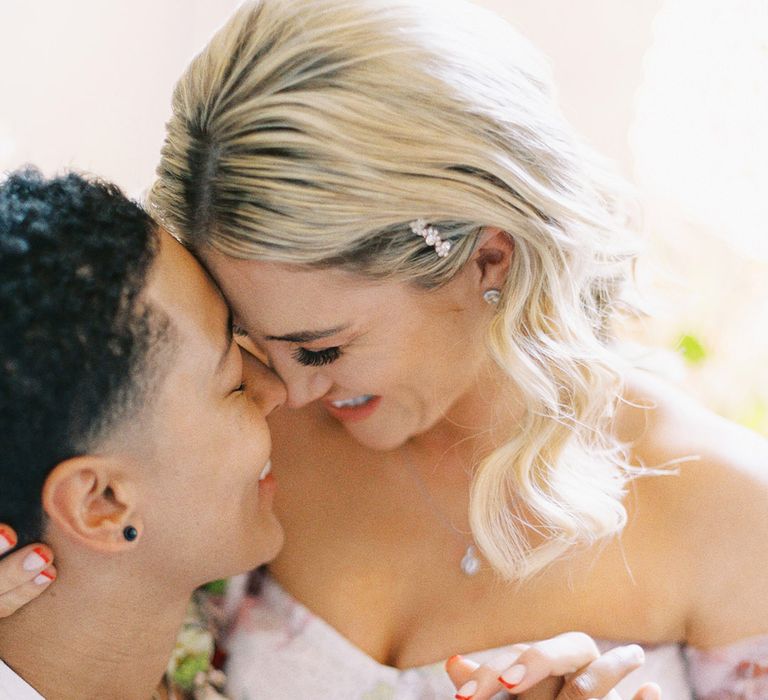 Bride with blonde wavy hair and red manicured nails holding hands with her partner at their Barnett Hill Hotel wedding 