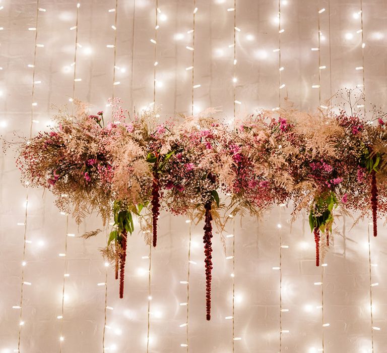 Dried flower colourful pink flower cloud for wedding reception with fairy lights behind the top table