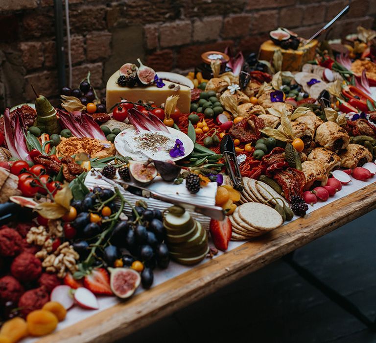 Huge bright and colourful grazing board for wedding guests to munch on 