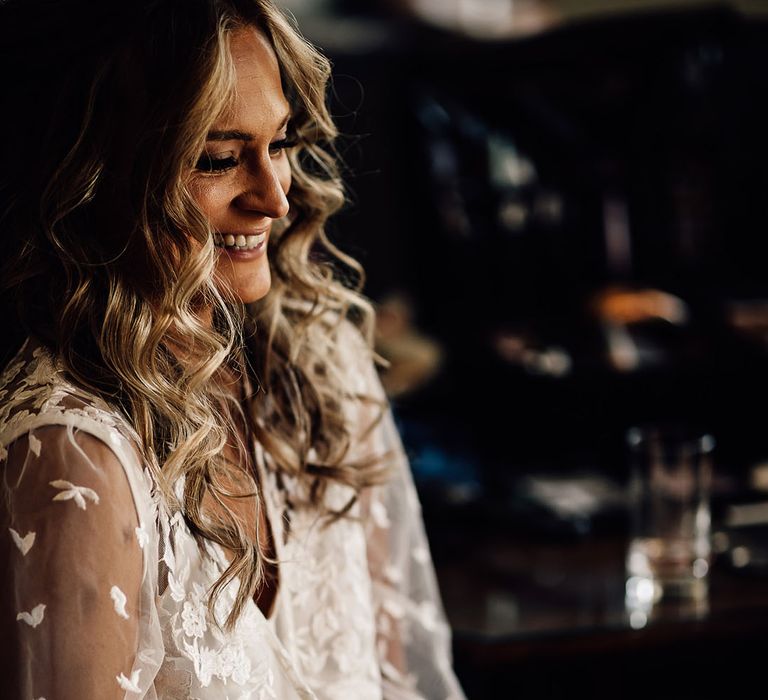 Bride gets ready for her wedding day wearing sheer lace robe with French tip wedding nails 