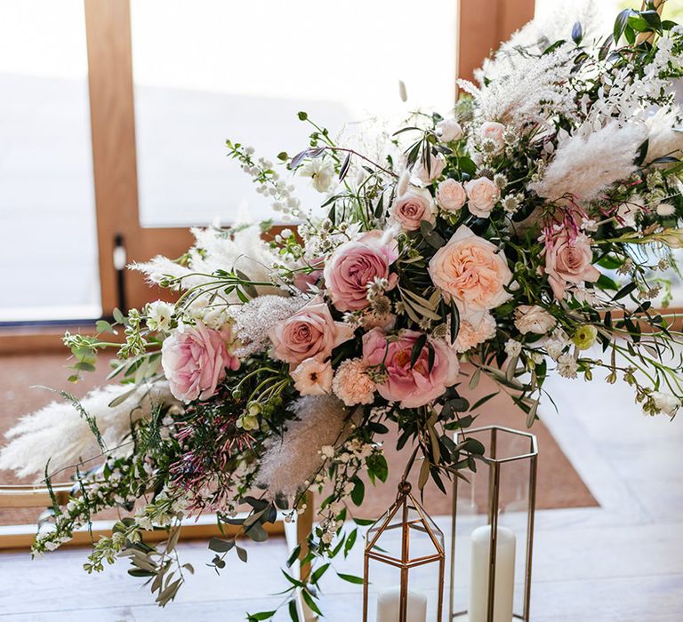 Pink roses with dried grasses and foliage wedding flower decor 