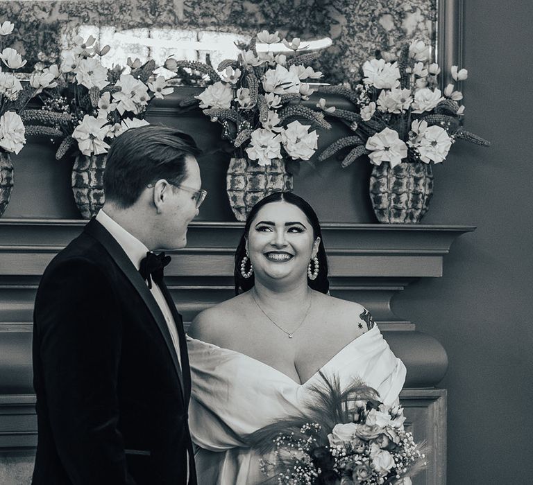 Bride wears ASOS curve wedding dress as she looks lovingly at her groom during wedding ceremony at the Old Marylebone Town Hall