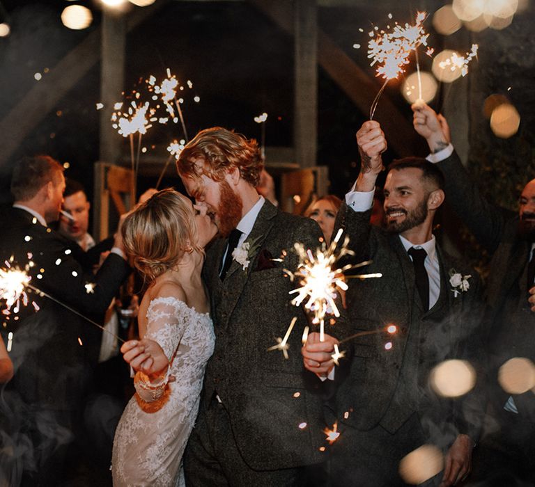 Bride in lace mermaid wedding dress and groom have sparkler send off from their wedding at Stone Barn