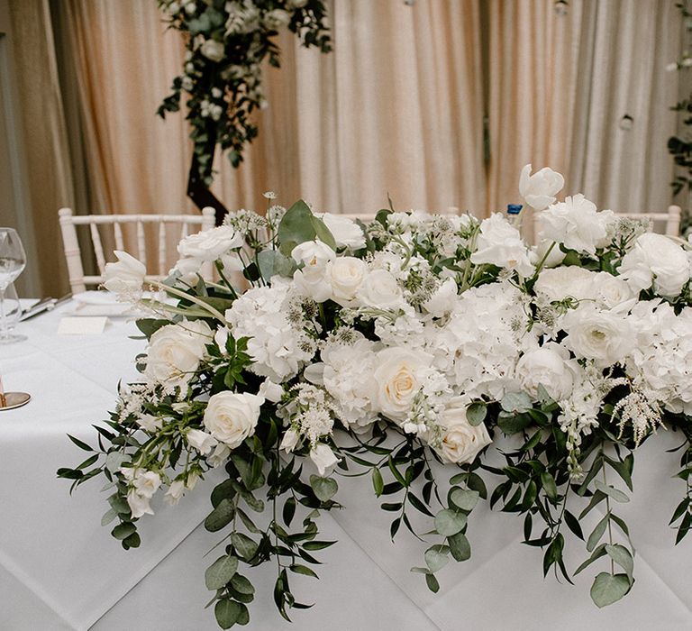 Classic white floral centrepieces with green foliage 