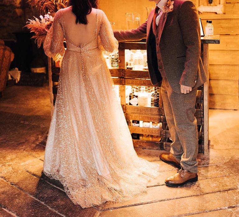 Bride & groom stand beneath neon Gin Bar sign in bright pink 