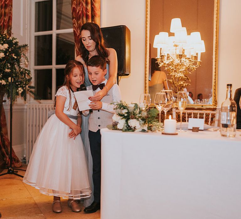 The flower girl and page boy do a reading at the wedding reception 