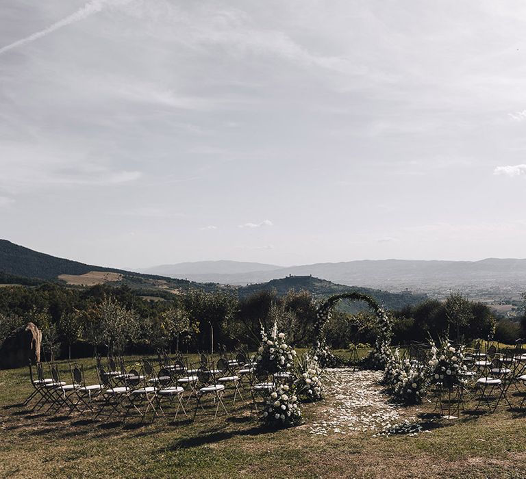 Castello di Petrata outdoor wedding ceremony with floral arch and beautiful mountain scenery to the background