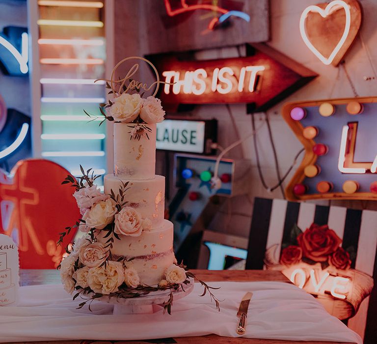 Three tiered buttercream wedding cake with personalised laser cut wedding topper, gold icing and rose and foliage cake decor 