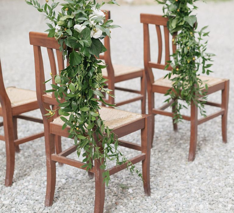 Dark wooden chair with large wedding foliage decoration for wedding ceremony in Tuscany 