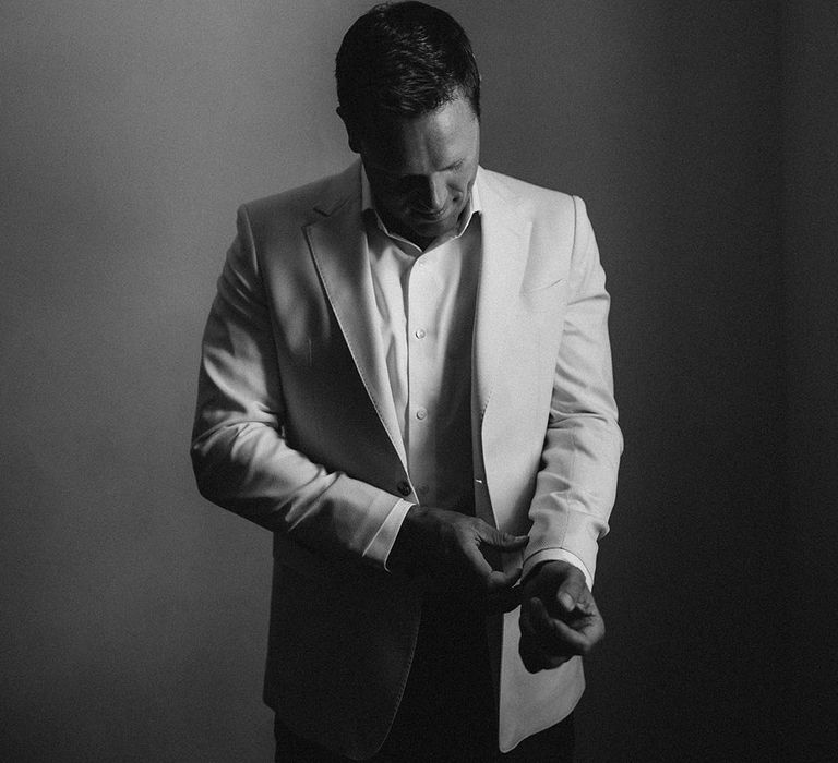 Groom gets ready on the morning of his wedding day in black & white image