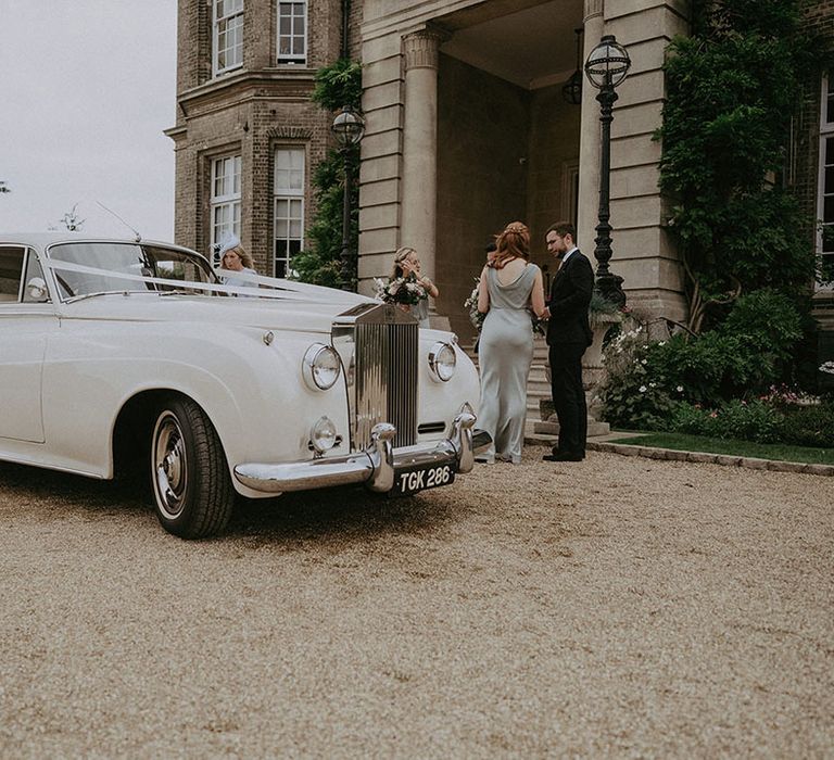 Vintage wedding car complete with white ribbon to the front 