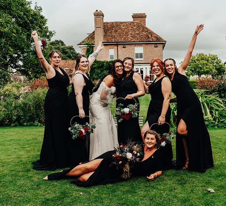 Bridesmaids in black bridesmaid dresses with heart shaped bouquets with the bride in a beaded wedding dress 