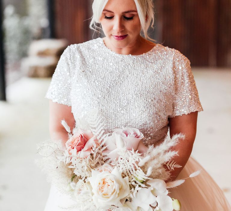 Short sleeve beaded bridal top with bridal separates wearing her hair in an updo with pink and white bouquet with pink ribbon 