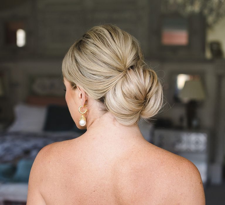 Bride wearing her blonde hair in a traditional updo hairstyle 