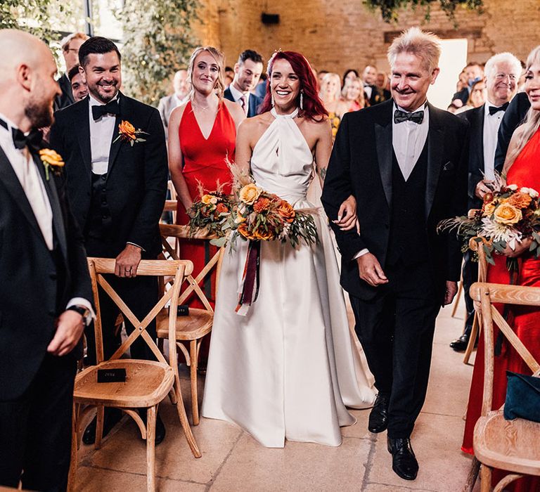 Father of the bride in black tuxedo walking the bride down the aisle to the groom at Old Gore Barn in the Cotswolds 