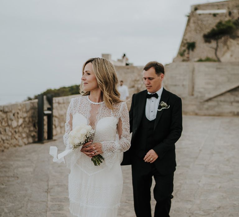 Ibiza destination wedding with bride in a lace wedding dress holding an all white wedding bouquet