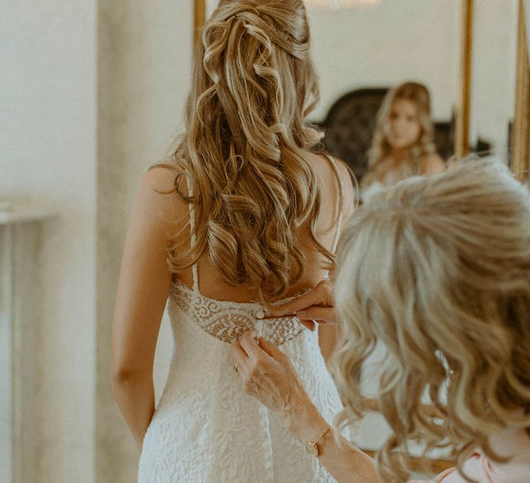 Bride in twisted half up half down wedding hair in button back wedding hair