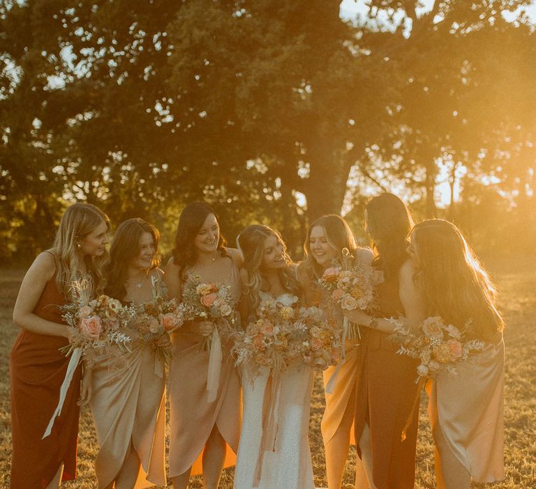 Bridesmaids in autumnal bridesmaid dresses in satin fabric with classic wrap style 