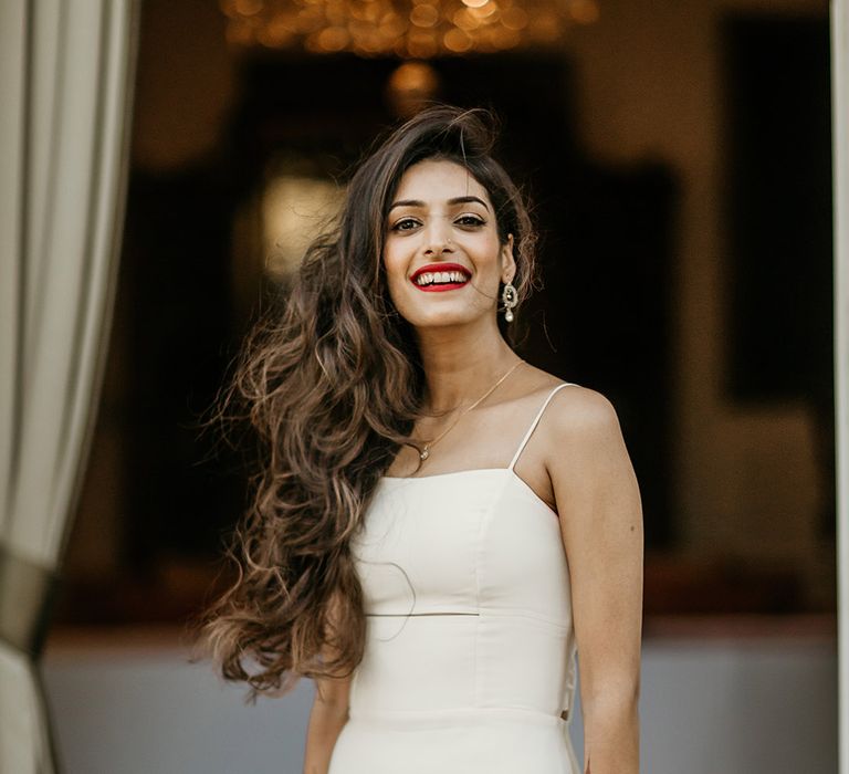 Bride with gorgeous thick brown tousled hair wearing a fitted spaghetti strap slip dress 