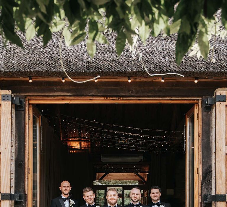 Groomsmen in tuxedos at rustic luxe wedding