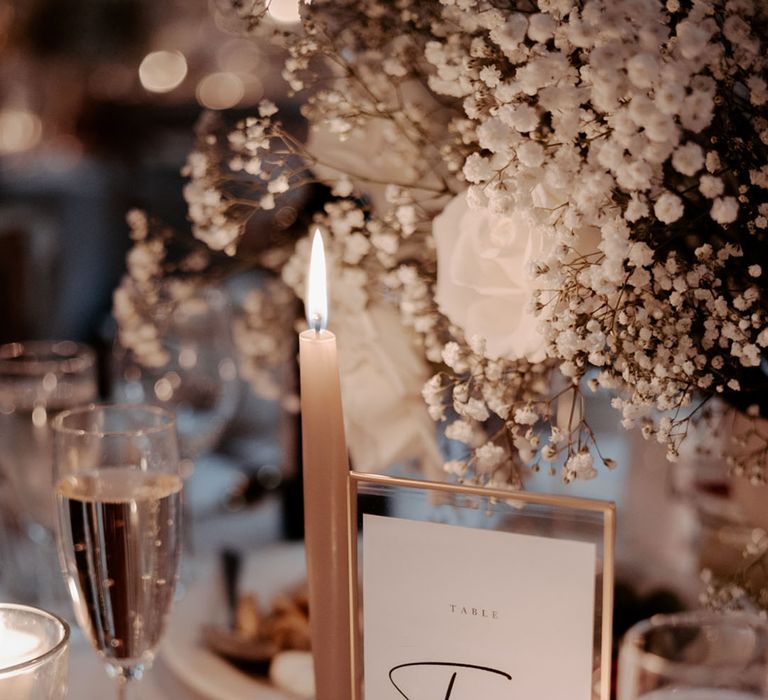 Romantic Wyresdale Park wedding with white gypsophila table centrepiece with tea lights and candles with wedding table number sign 