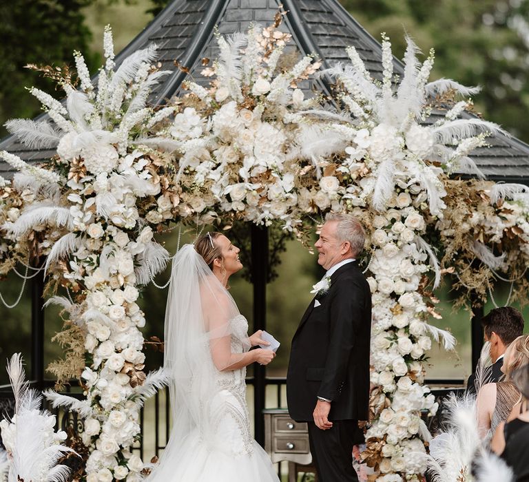 White flower arrangements with pampas grass for altar decorations 