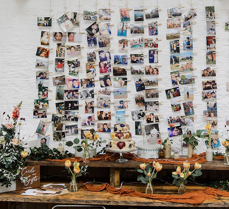 Photo picture table plan wall above wedding dessert table 