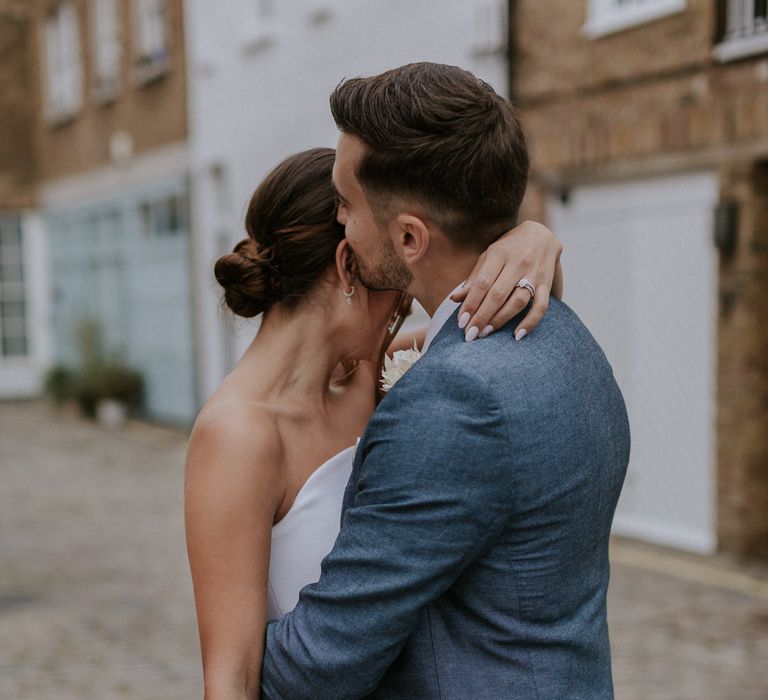 Bride and groom embracing in London streets 