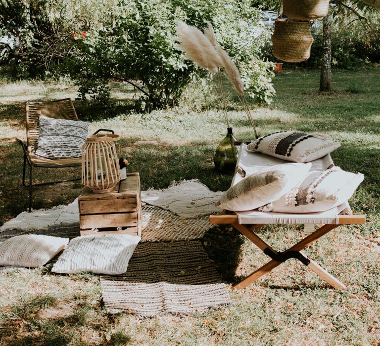 Outdoor seating area with rugs, cushions and wicker baskets 