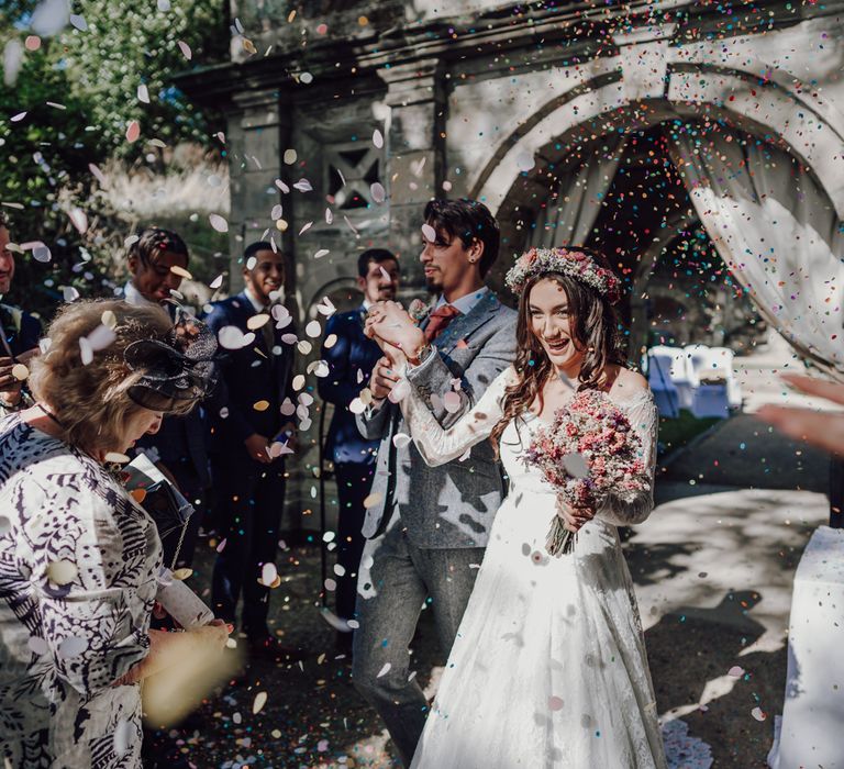 Bride and groom walk through confetti cannons