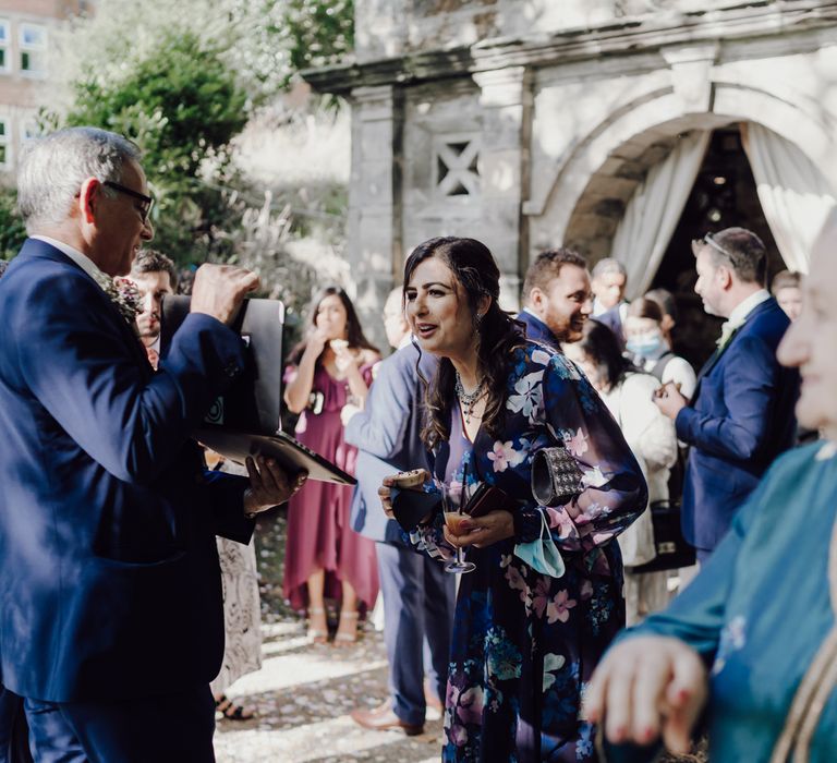 Wedding guest chatting to friends over laptop for virtual wedding