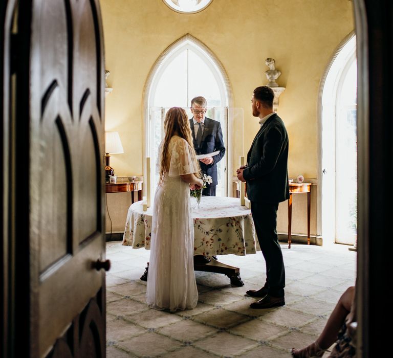 Bride & groom through arch doorway 