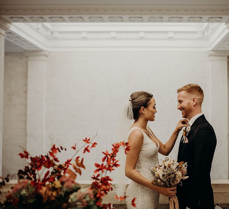 Pregnant bride adjust her grooms tie