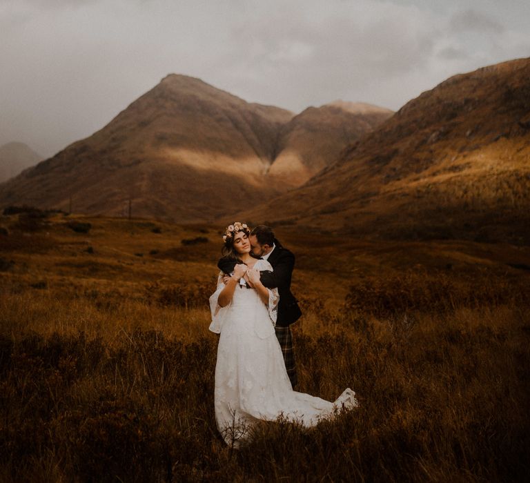 Bride and groom embrace on the moors at highland wedding in Glencoe