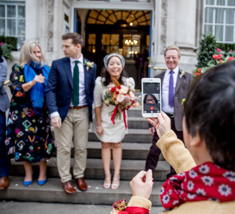 Wedding guests live streaming a micro wedding 