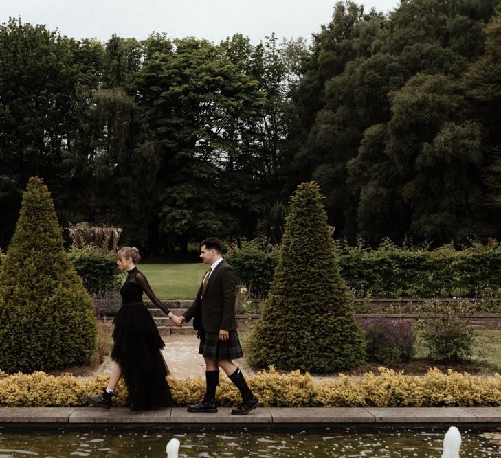 Bride & groom walk along the grounds together in Scottish elopement