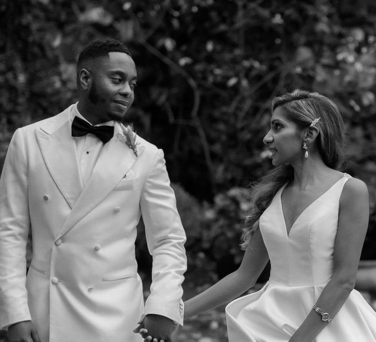 Black and white wedding portrait of the bride and groom holding hands by Paul and Nanda photography 