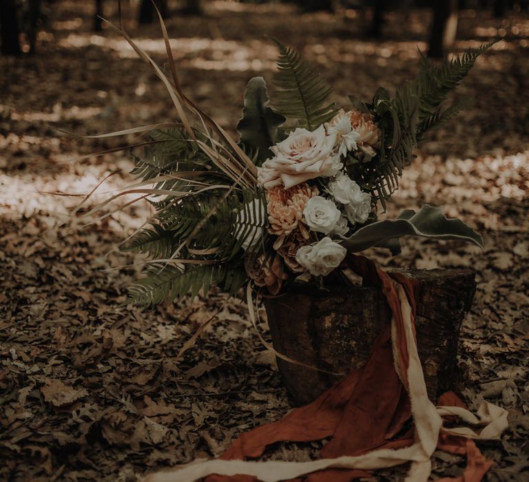 White, orange and green boho wedding bouquet tied with ribbon 