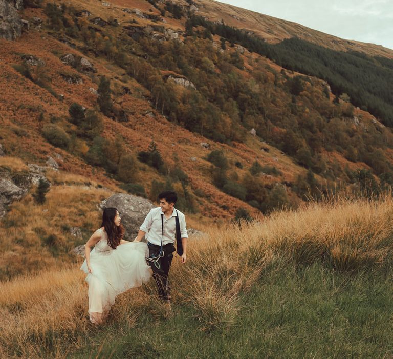 Couple walk together through Scotland in the countryside 