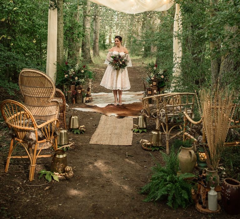 Bride stands under trees with lights hanging down