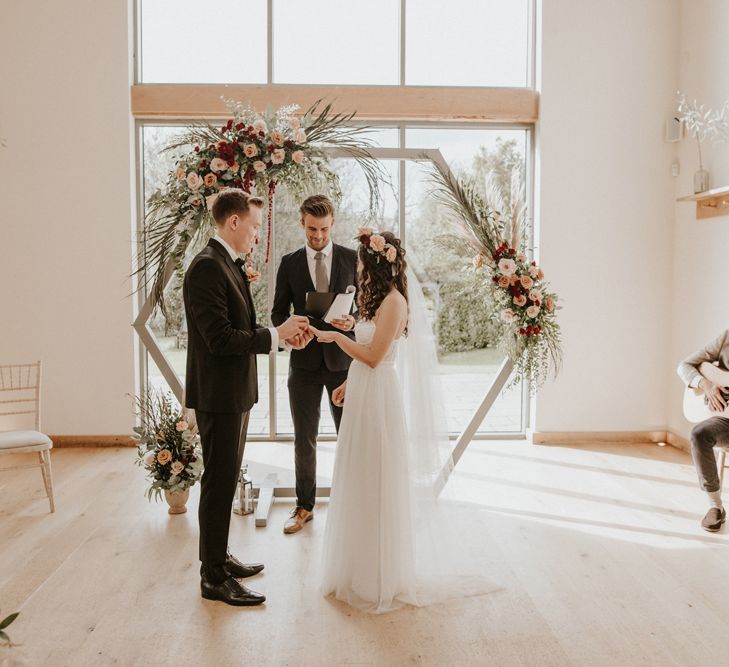 Micro wedding at Millbridge Court with wooden frame altar decorated in flowers 