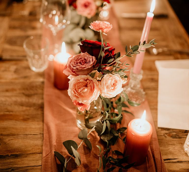 Different shades of pink roses line table for wedding reception