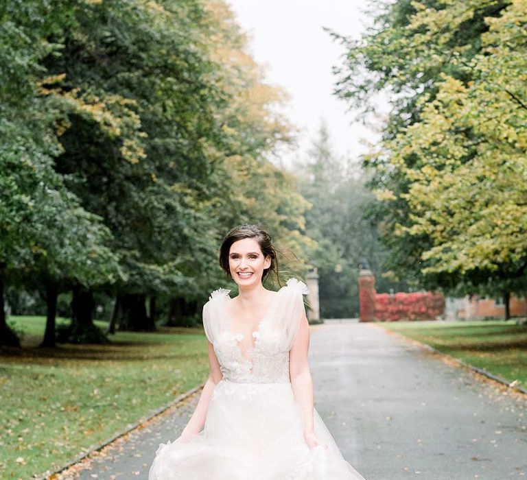 Bride in a romantic tulle and lace wedding dress running 