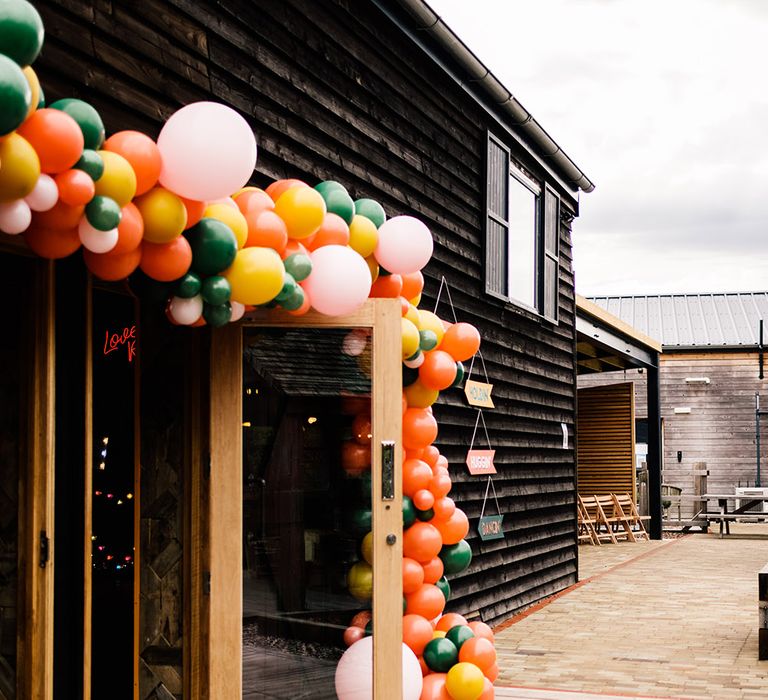 Colourful balloon installation decorating the wedding venue entrance 