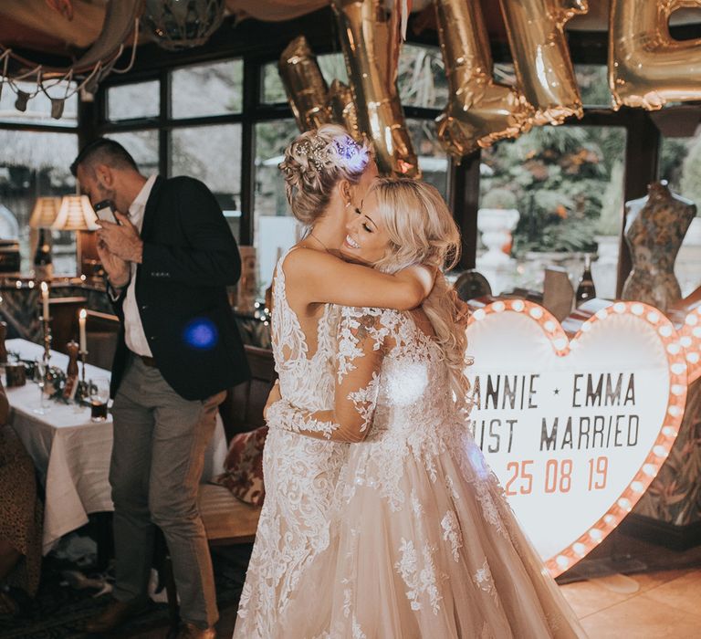 Two brides have a first dance at their wedding reception.