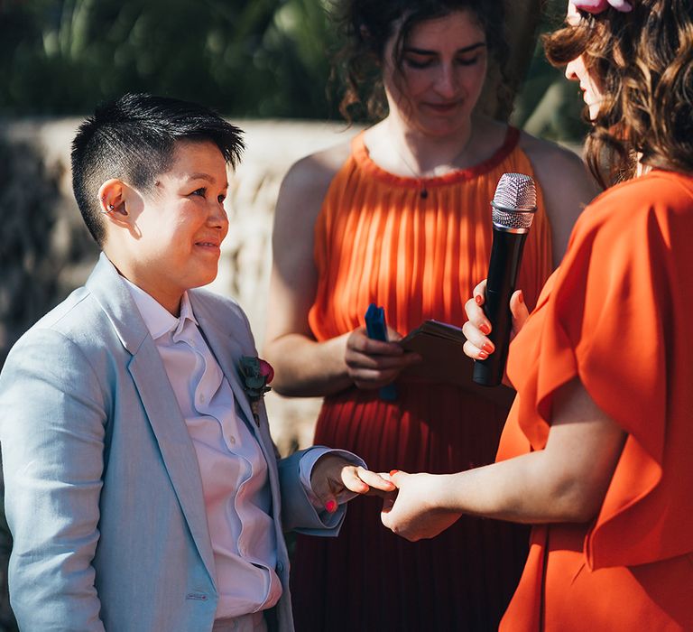 Brides exchange rings during vows 